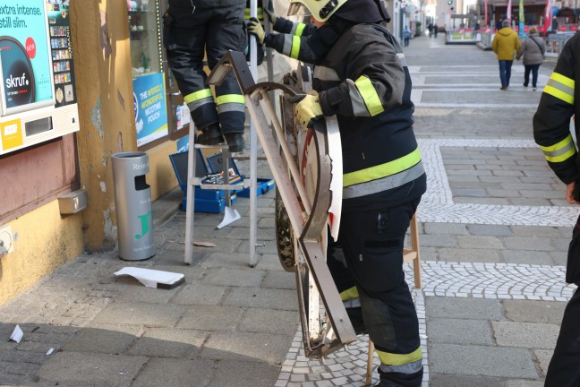 Verkehrsunfall: Beschdigte Leuchtreklamen einer Trafik in Wels-Innenstadt von Feuerwehr demontiert